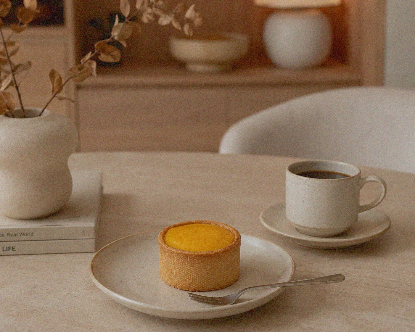 Tea and a Bear Fruit pudding set out on a quiet table